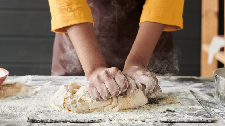 person kneading dough