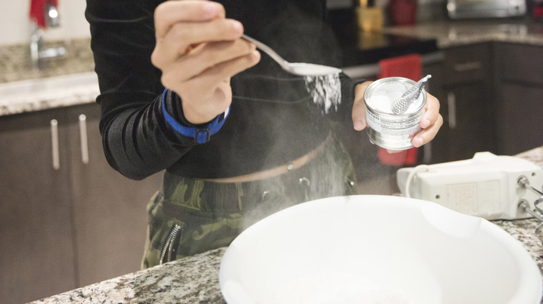 person measuring baking soda