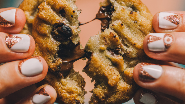 fingers pulling a chewy warm cookie apart