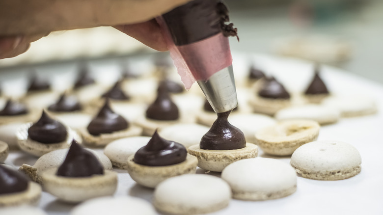 filling macarons on baking sheet