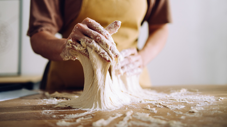 Woman lifting sticky dough