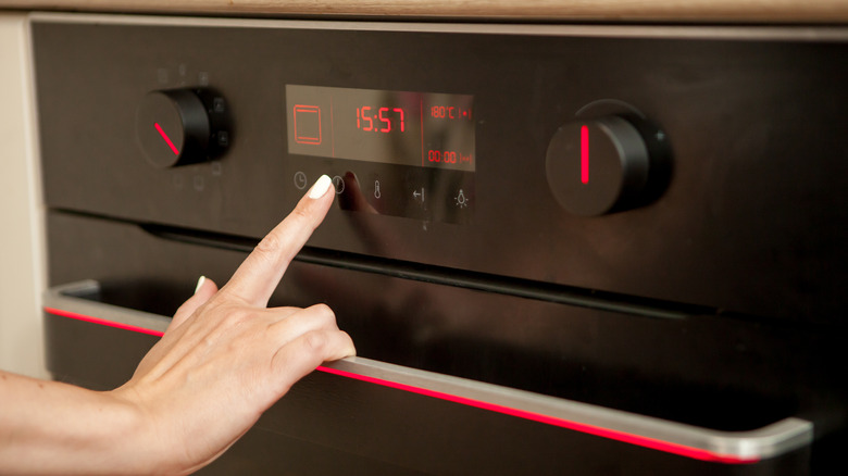 touching control panel on oven