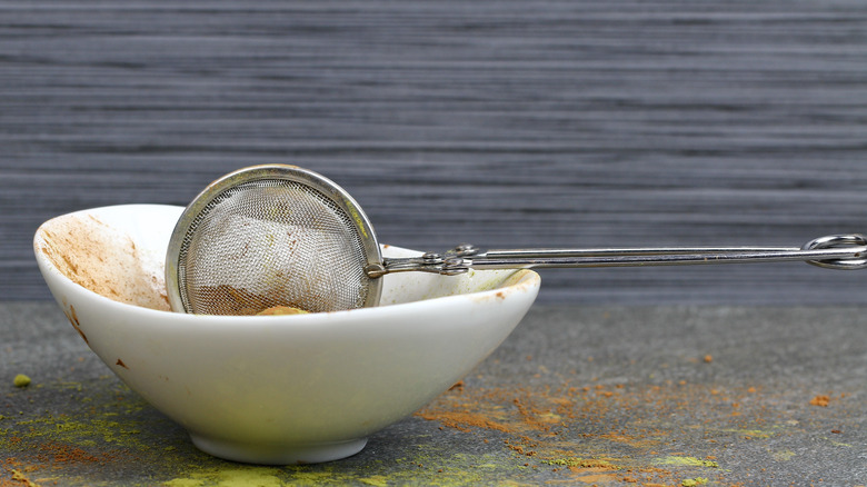 Dirty tea strainer resting in bowl