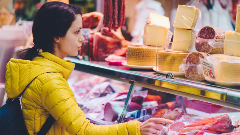 Woman stands at deli counter