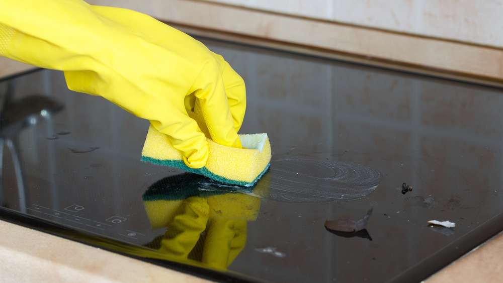 cleaning glass stovetop with sponge