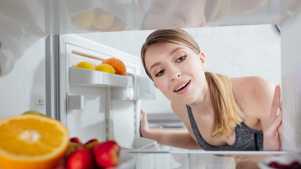 woman examining her clean refrigerator