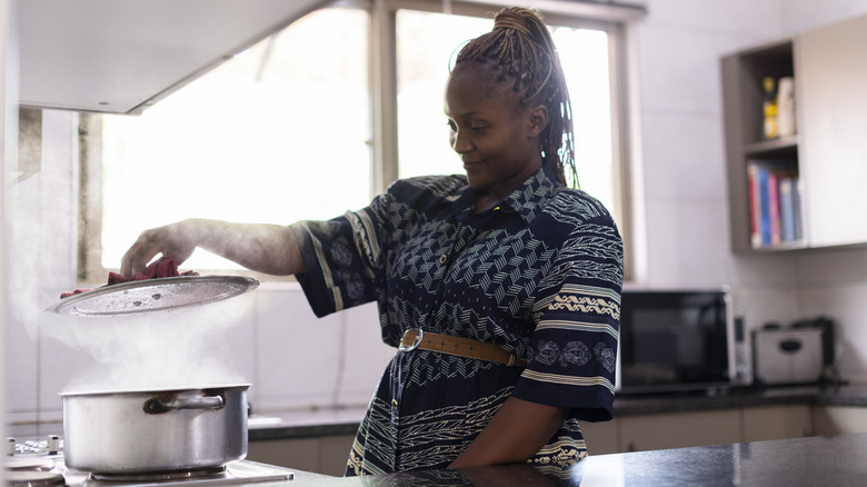 woman lifts pot lid