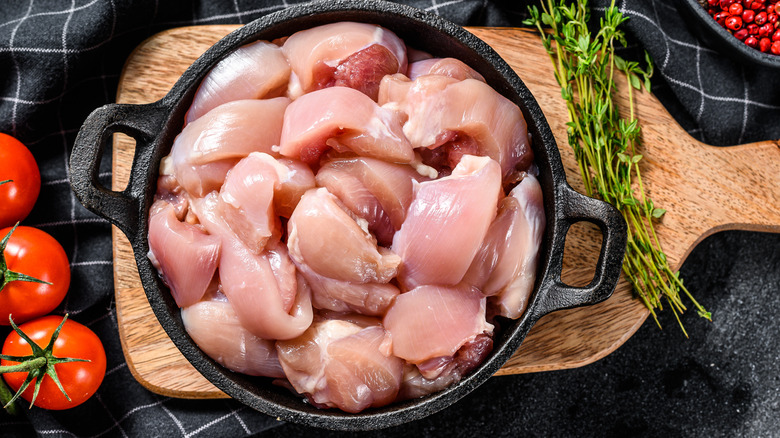 Raw chicken thighs in pan 