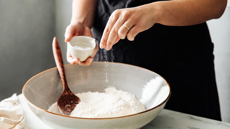 sprinkling salt into flour