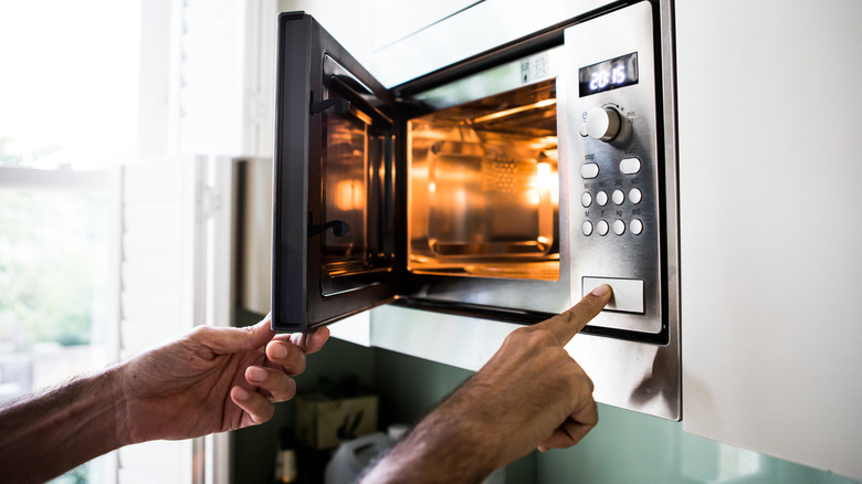 man opening microwave oven