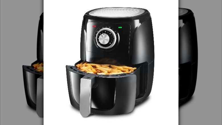 Potatoes cooking in a black air fryer