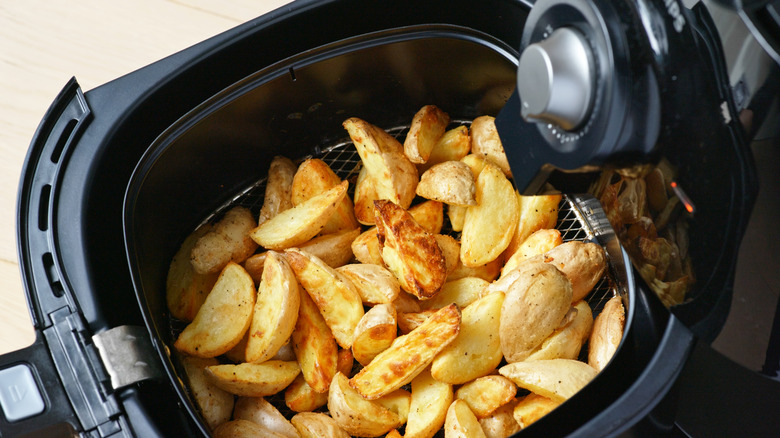 Air fryer basket filled with potatoes