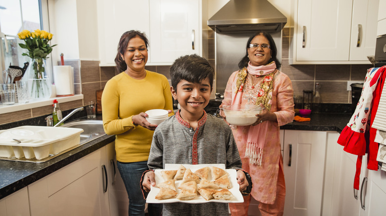 child displaying plate of samosas