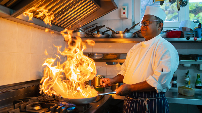 chef cooking with flaming pan