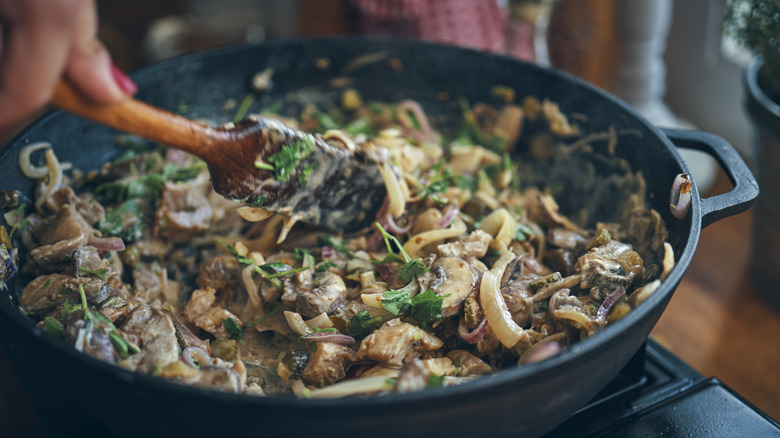 Wooden spoon stirring stroganoff