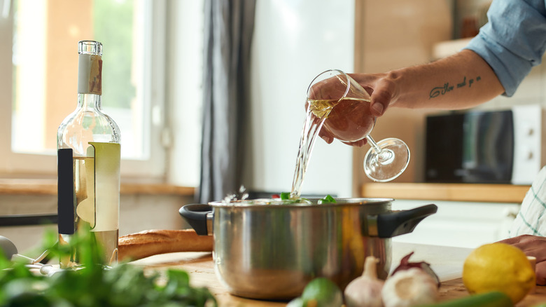 Person pouring wine into pot