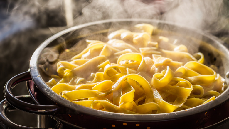 Steaming egg noodles in colander