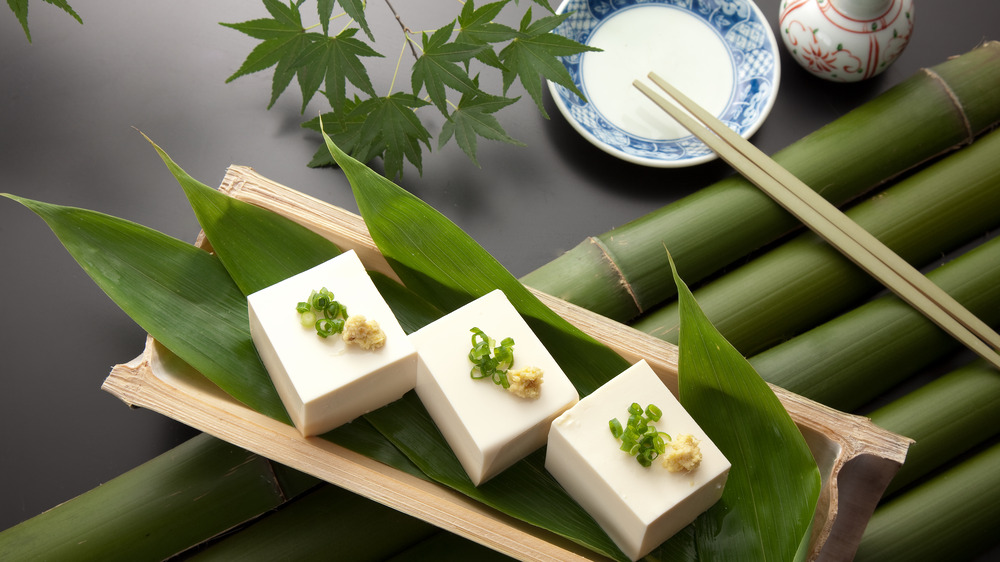 blocks of tofu on leaves with chopsticks