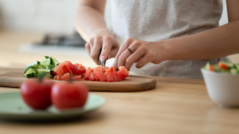 hands cutting tomato