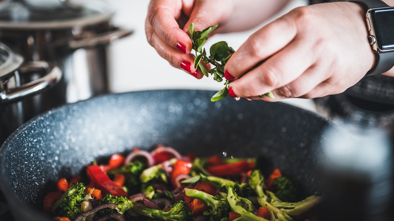 Adding basil to pan