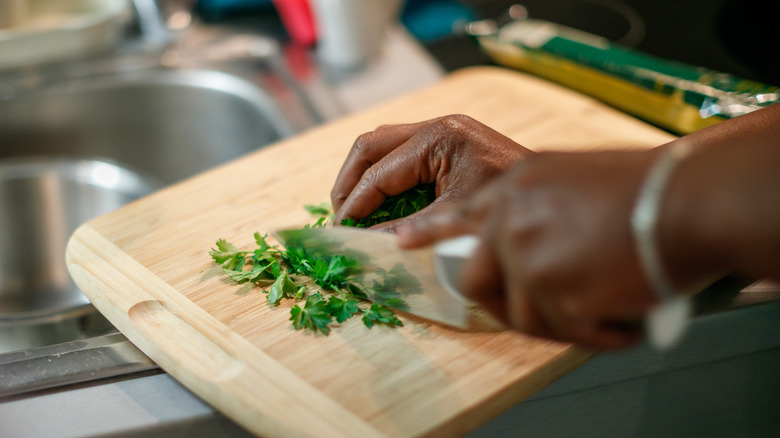 Hands chopping fresh herbs