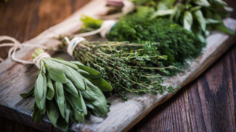 Bundles of herbs on chopping board