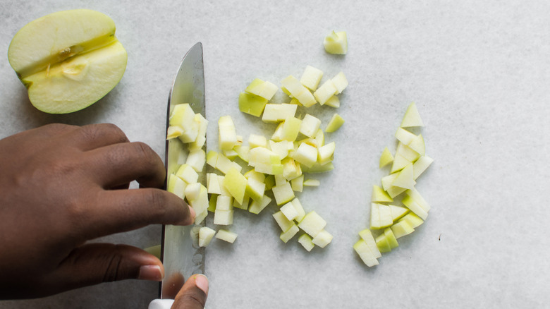 hands dicing apples