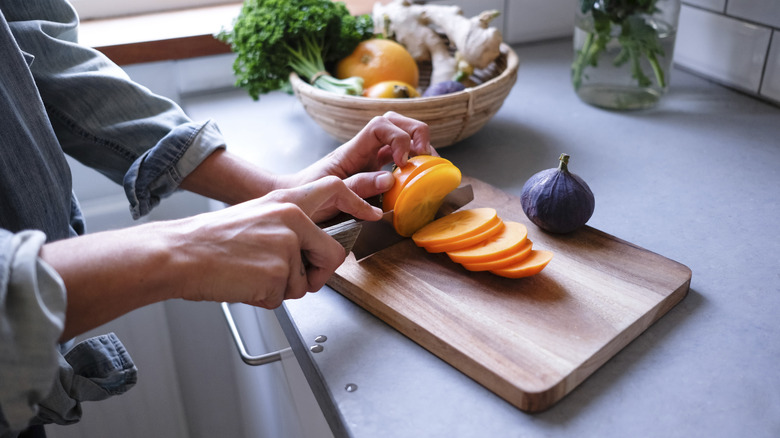 hands chopping fruit