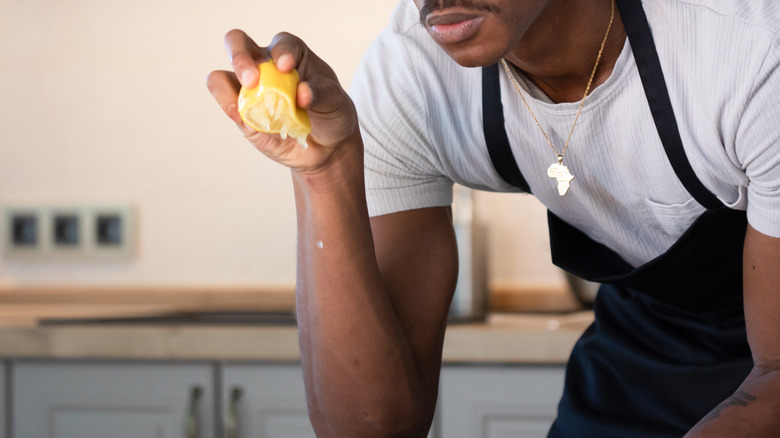 lemon being squeezed into dish