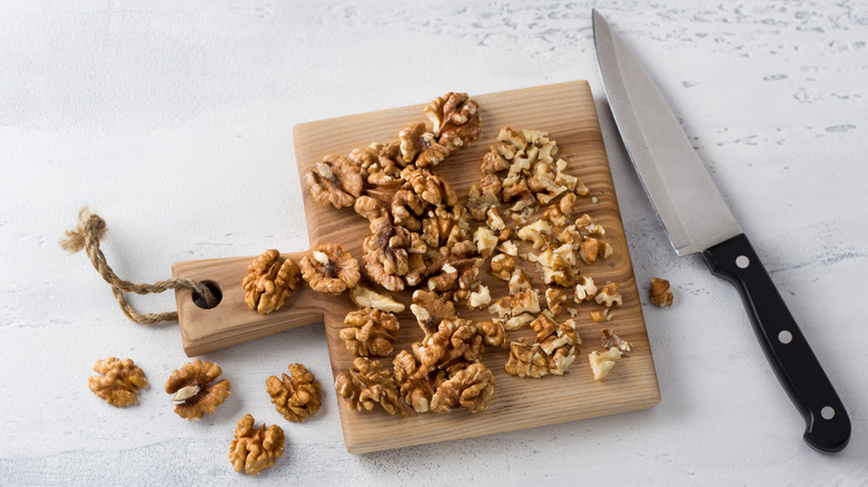 Walnuts on a wooden cutting board with knife