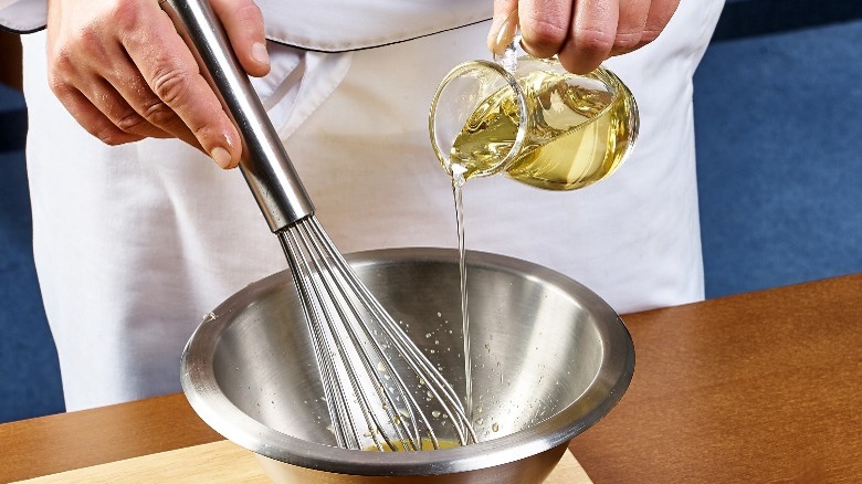 chef pouring oil into bowl