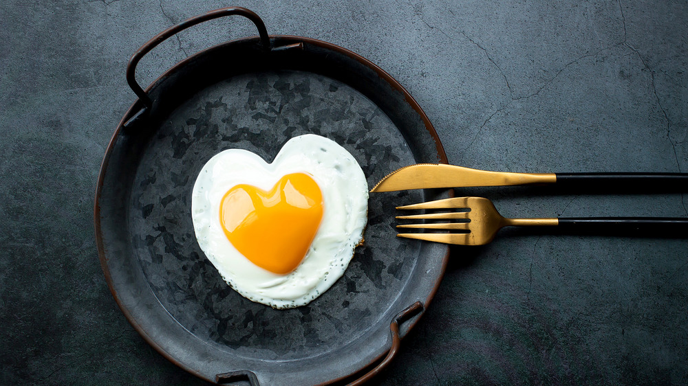 heart shaped fried egg in cast iron pan