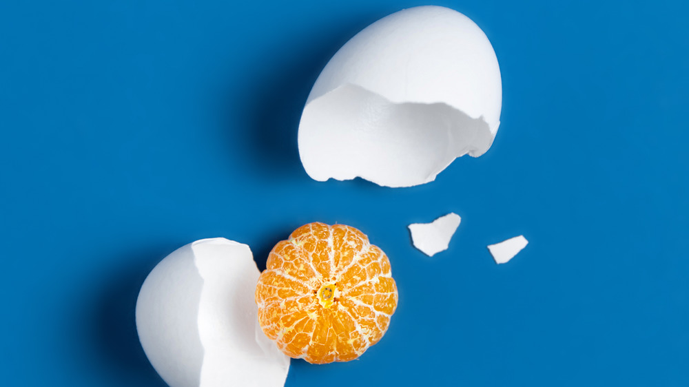 cracked white egg shell with tangerine