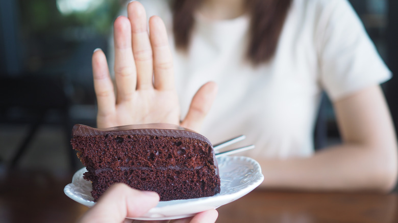 Hand refusing chocolate cake