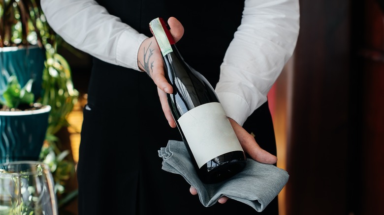 sommelier holding wine bottle