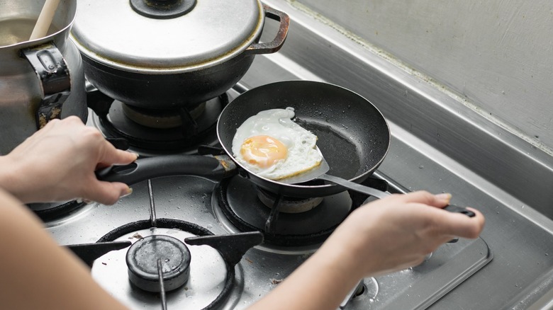 person flipping fried egg on stove