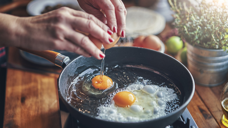 person cooking eggs on pan