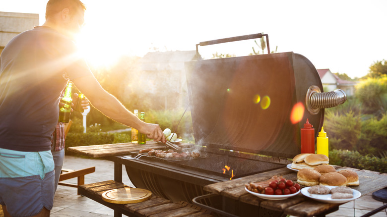 man at grill with hamburger buns