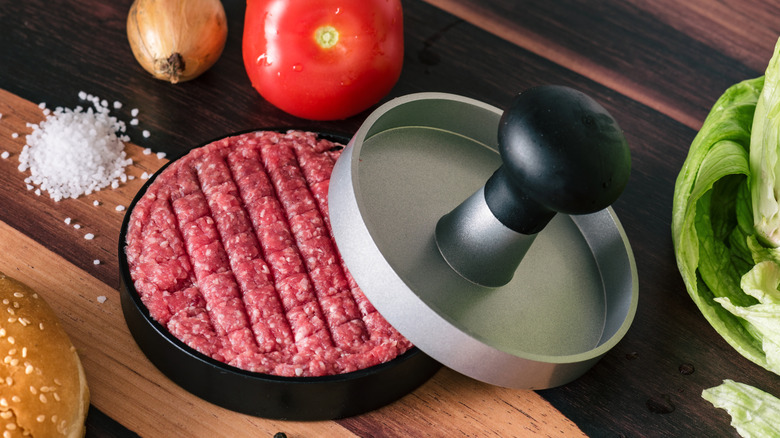 burger meat inside a press 