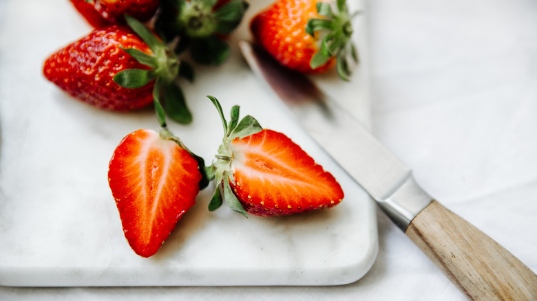 Sliced strawberries on board