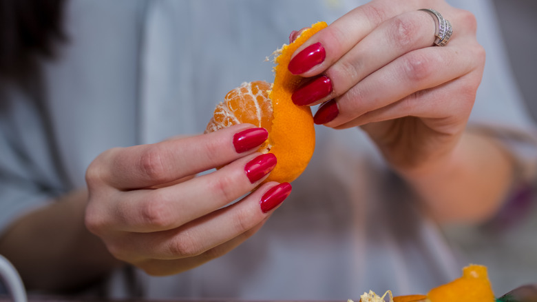 Woman peeling orange