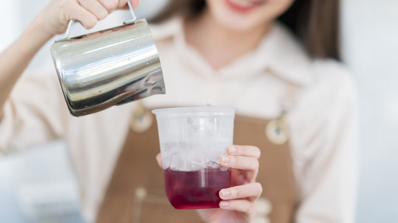 Woman pouring drink into cup