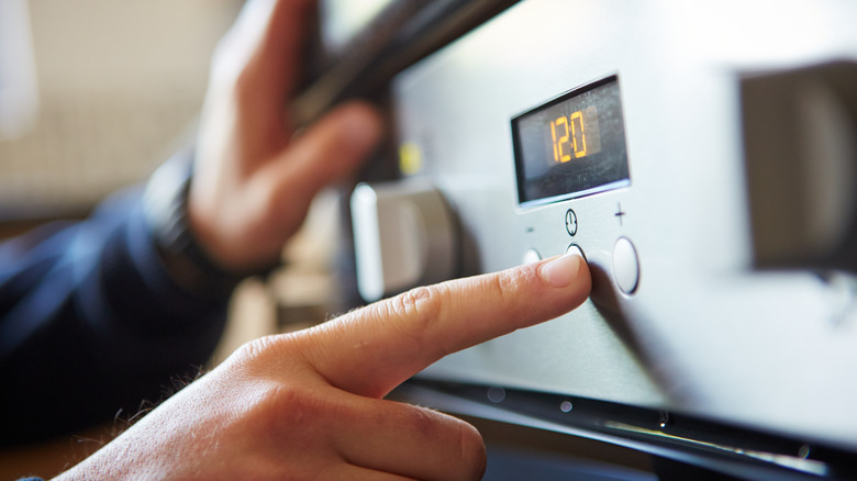 Close-up of a male hand starting an oven