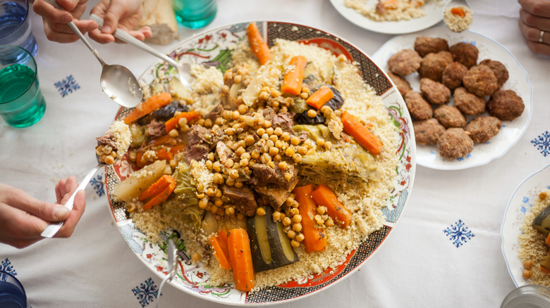 group eating from large platter of couscous