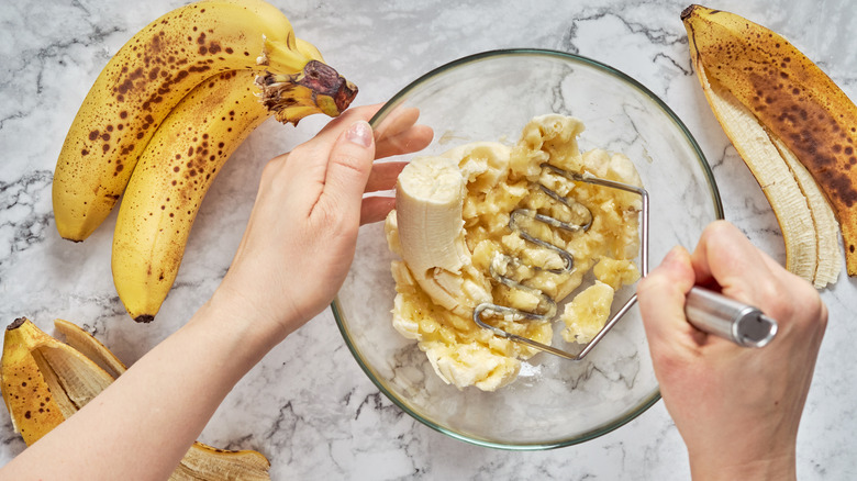 bananas being mashed in bowl