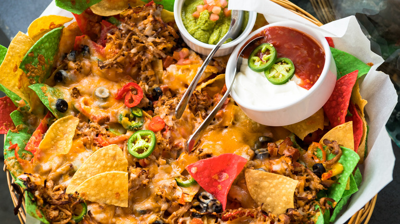 Nachos with bowls of salsa and sour cream