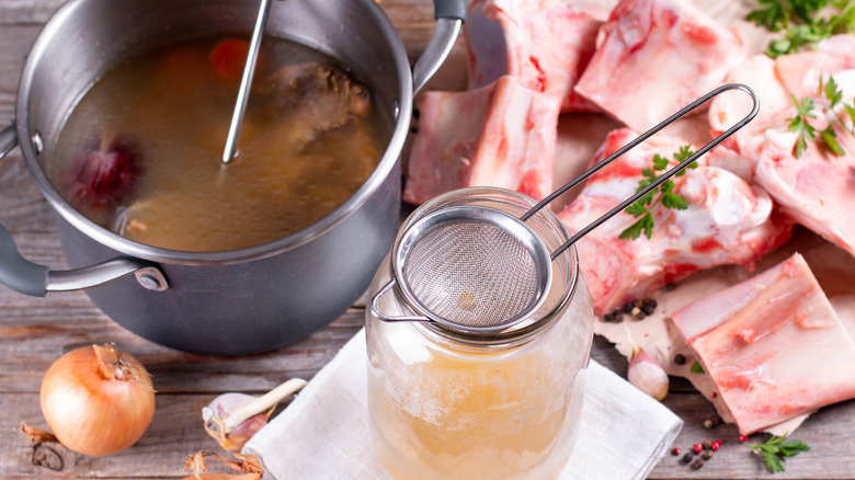 Straining homemade stock into jar