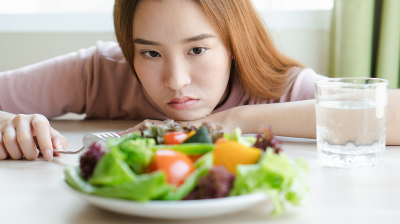 woman looking bored with salad