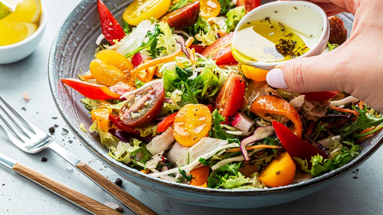 pouring dressing on salad