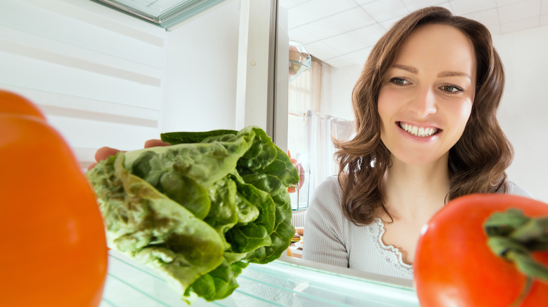 woman with lettuce in fridge